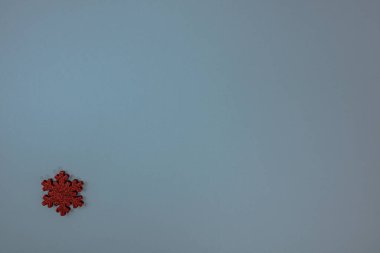 Kırmızı parıltılı kar tanesi süslemeli mavi Noel arkaplanı. Noel kompozisyonunu kopyalamak için üst görünüm.