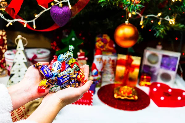 Hand Hand Mit Schokoladenbonbons Vor Dem Weihnachtsbaum Christbaum Schmücken Oder — Stockfoto