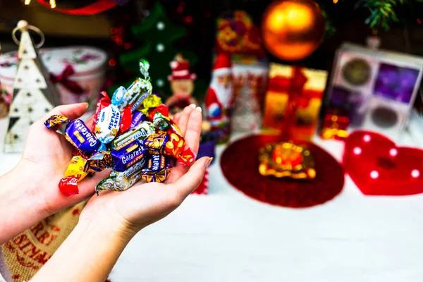 Hand Hand Mit Schokoladenbonbons Vor Dem Weihnachtsbaum Christbaum Schmücken Oder — Stockfoto