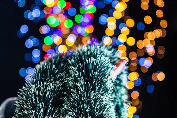 Arka planda bulanık ışıklarla izole edilmiş Noel çelenkleri duruyor. Aralık sezonu, Noel kompozisyonu.