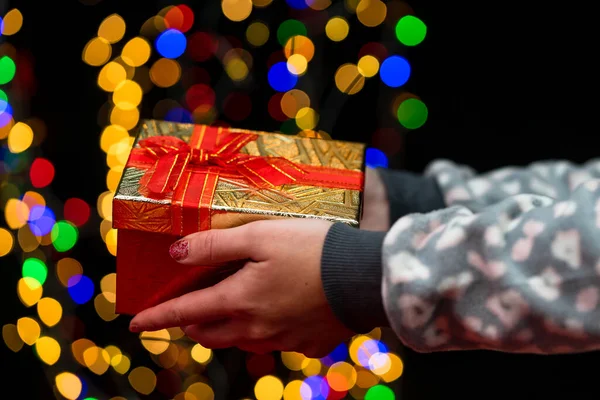女人的手拿着圣诞装饰品 圣诞节和新年背景 圣诞装饰品和模糊不清的灯光 — 图库照片