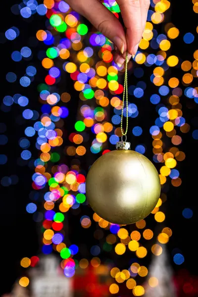 Tenendo Decorazione Natale Contro Bokeh Luci Sfondo — Foto Stock