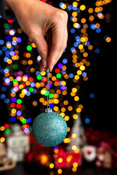 Memegang Dekorasi Natal Terhadap Latar Belakang Lampu Bokeh — Stok Foto