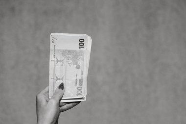 El ele tutuşup para göstermek ya da para vermek. Dünya para kavramı, 100 EURO banknotları izole edilmiş para birimi. Zengin iş adamları kavramı, para biriktirmek ya da harcamak.