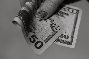 Eller rüşvet ya da bahşiş gibi para veriyor. Bulanık bir arka planda Amerikan doları banknotları, Amerikan para birimi