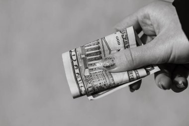 Eller rüşvet ya da bahşiş gibi para veriyor. Bulanık bir arka planda Amerikan doları banknotları, Amerikan para birimi