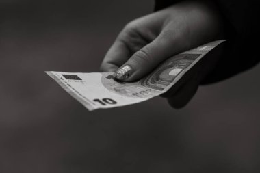 Kız elleri para veriyor. Bulanık bir arkaplanda EURO banknotları tutuluyor