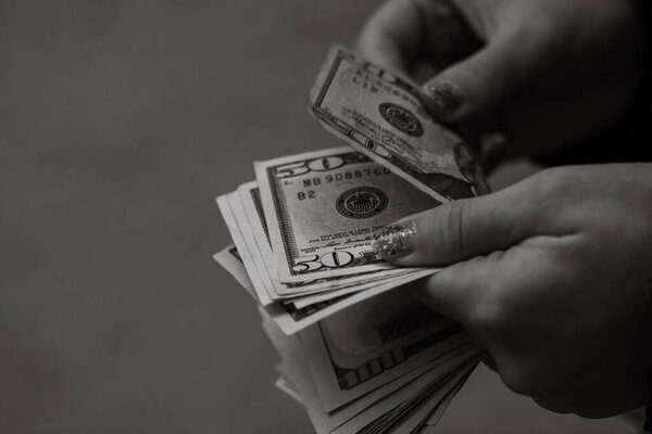 Selective focus on detail of USD banknotes. Counting or giving United States Dollars banknotes. World money concept, inflation and economy concept