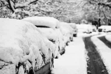 Yılın ilk kar yağışından beri karla kaplı arabalar. Kış konsepti, sokağa park etmiş karlı arabalar, derin kar tabakası.