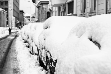 Yılın ilk kar yağışından beri karla kaplı arabalar. Kış konsepti, sokağa park etmiş karlı arabalar, derin kar tabakası.