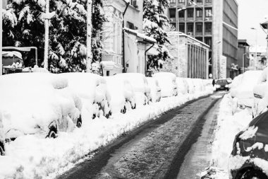 Yılın ilk kar yağışından beri karla kaplı arabalar. Kış konsepti, sokağa park etmiş karlı arabalar, derin kar tabakası.