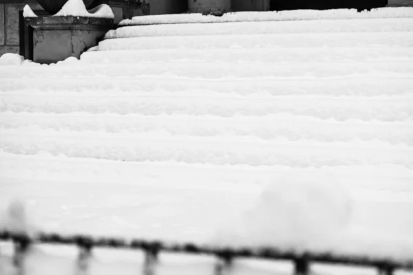 Stairs covered with snow from the first snow fall of the year. Winter concept, snowy staircase covered with a deep layer of snow