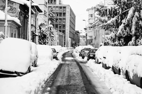 Snow on cars in the morning. Winter season and icy cars on the road in morning rush hour traffic of Bucharest, Romania, 2020