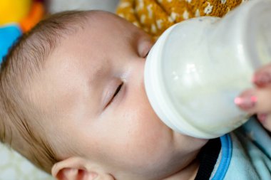 Şişeyle yeni doğmuş bebeği besle. Annelik ve sağlıklı yaşam tarzı kavramı