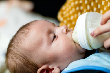 Şişeyle yeni doğmuş bebeği besle. Annelik ve sağlıklı yaşam tarzı kavramı
