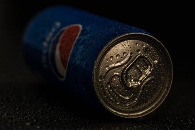 Pepsi kutusunun siyah arka plandaki su damlacıklarıyla çekilmiş resmi. Stüdyo çekimi Bükreş, Romanya, 2021