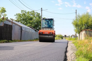 İşçiler ve asfaltlama makineleri. Romanya 'nın Bükreş kentinde inşaat ve yeni karayolunun asfaltlanması, 2022