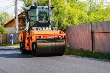 İşçiler ve asfaltlama makineleri. Romanya 'nın Bükreş kentinde inşaat ve yeni karayolunun asfaltlanması, 2022