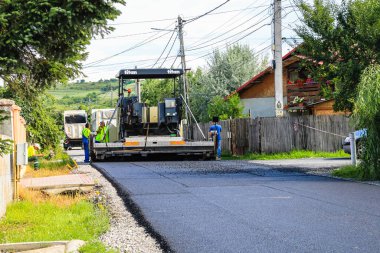 İşçiler ve asfaltlama makineleri. Romanya 'nın Bükreş kentinde inşaat ve yeni karayolunun asfaltlanması, 2022