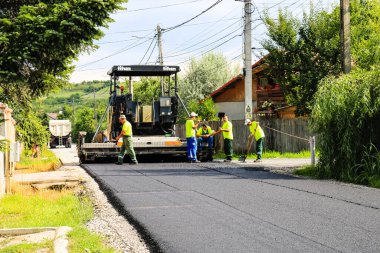 İşçiler ve asfaltlama makineleri. Romanya 'nın Bükreş kentinde inşaat ve yeni karayolunun asfaltlanması, 2022