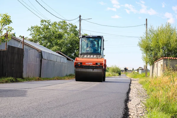 İşçiler ve asfaltlama makineleri. Romanya 'nın Bükreş kentinde inşaat ve yeni karayolunun asfaltlanması, 2022