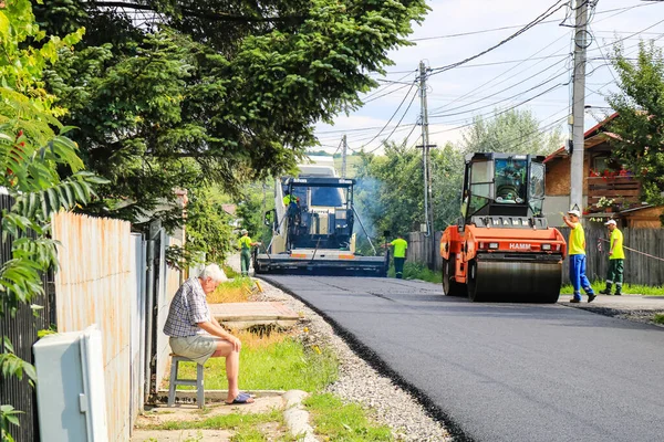 İşçiler ve asfaltlama makineleri. Romanya 'nın Bükreş kentinde inşaat ve yeni karayolunun asfaltlanması, 2022