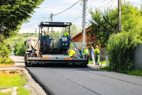 İşçiler ve asfaltlama makineleri. Romanya 'nın Bükreş kentinde inşaat ve yeni karayolunun asfaltlanması, 2022