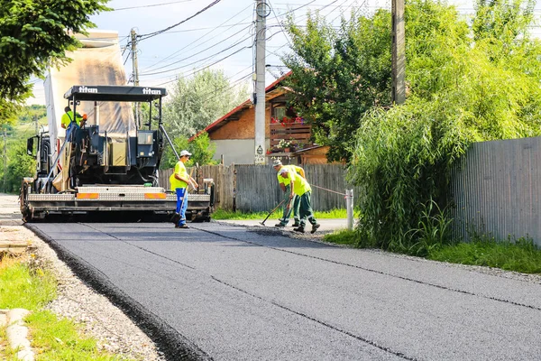 İşçiler ve asfaltlama makineleri. Romanya 'nın Bükreş kentinde inşaat ve yeni karayolunun asfaltlanması, 2022