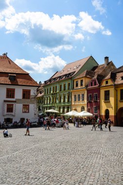 İnsanlar ve turistler Sighisoara, Romanya 'nın eski kalesinde 2022' de dolaşıyorlar.