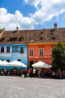 İnsanlar ve turistler Sighisoara, Romanya 'nın eski kalesinde 2022' de dolaşıyorlar.
