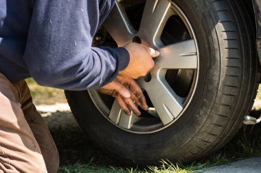 Romanya 'nın Bükreş kentindeki araba garajında araba tamircisi lastik değiştiriyor.