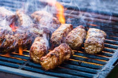 Mangalda mici ya da mititei denilen rulo köfteleri hazırlıyorum. Izgarayı alev ve dumanla yakın..