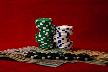 Kırmızı arka planda parası olan poker çipleri yığını