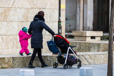 2022 Bükreş, Romanya 'da çocuklu bekar bir anne bebek arabasıyla geziyor.