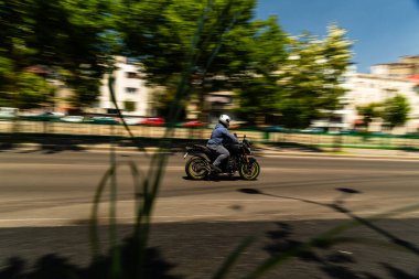 Biker on a motorcycle in traffic at rush hour in downtown area of the city in Bucharest, Romania, 2022