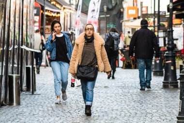 People and tourists wander the streets of the Bucharest Old Town, Romania, 2022
