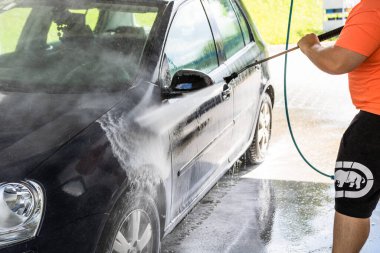 Otomobil yıkama istasyonunda araba yıkama ve temizleme. Romanya 'nın Bükreş kentinde yüksek basınçlı su kullanan araba yıkama, 2021