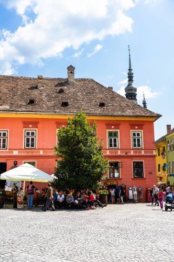 İnsanlar ve turistler Sighisoara, Romanya 'nın eski kalesinde 2022' de dolaşıyorlar.