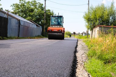 İşçiler ve asfaltlama makineleri. Romanya 'nın Bükreş kentinde inşaat ve yeni karayolunun asfaltlanması, 2022