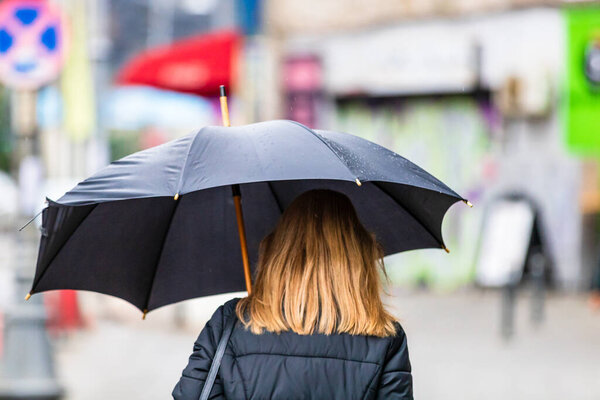 People with umbrella on the street on a rainy day in Bucharest, Romania, 2021