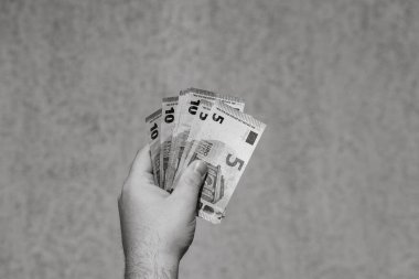 Avro parasını gösteren ve bahşiş, maaş gibi para veren ya da alan el ele tutuşmalar. 5 ve 10 EURO banknotları EUR izole edilmiş. Zengin iş adamları kavramı, para biriktirmek ya da harcamak.