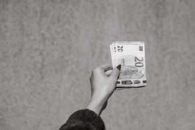 Avro parasını gösteren ve bahşiş, maaş gibi para veren ya da alan el ele tutuşmalar. 20 EURO banknotu EUR izole edilmiş. Zengin iş adamları kavramı, para biriktirmek ya da harcamak.