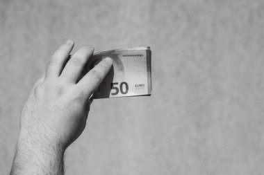 Avro parasını gösteren ve bahşiş, maaş gibi para veren ya da alan el ele tutuşmalar. 50 Avro banknotları izole edilmiş. Zengin iş adamları kavramı, para biriktirmek ya da harcamak.