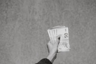 Avro parasını gösteren ve bahşiş, maaş gibi para veren ya da alan el ele tutuşmalar. 50 Avro banknotları izole edilmiş. Zengin iş adamları kavramı, para biriktirmek ya da harcamak.