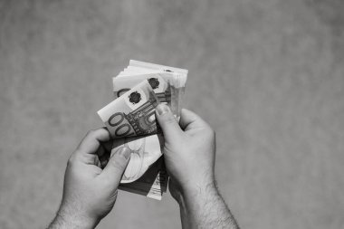 Avro parasını tutmak ve göstermek ya da para vermek. Dünya para kavramı, 100 avro banknot fotokopi alanı ile izole edilmiş para birimi. Zengin iş adamları kavramı, para biriktirmek ya da harcamak.