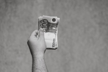 El ele tutuşup para göstermek ya da para vermek. Dünya para kavramı, 100 EURO banknotları izole edilmiş para birimi. Zengin iş adamları kavramı, para biriktirmek ya da harcamak.