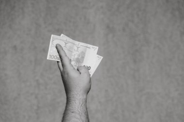 El ele tutuşup para göstermek ya da para vermek. Dünya para kavramı, 100 EURO banknotları izole edilmiş para birimi. Zengin iş adamları kavramı, para biriktirmek ya da harcamak.