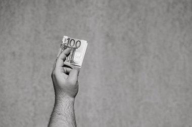 El ele tutuşup para göstermek ya da para vermek. Dünya para kavramı, 100 EURO banknotları izole edilmiş para birimi. Zengin iş adamları kavramı, para biriktirmek ya da harcamak.
