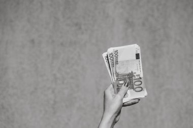 El ele tutuşup para göstermek ya da para vermek. Dünya para kavramı, 100 EURO banknotları izole edilmiş para birimi. Zengin iş adamları kavramı, para biriktirmek ya da harcamak.