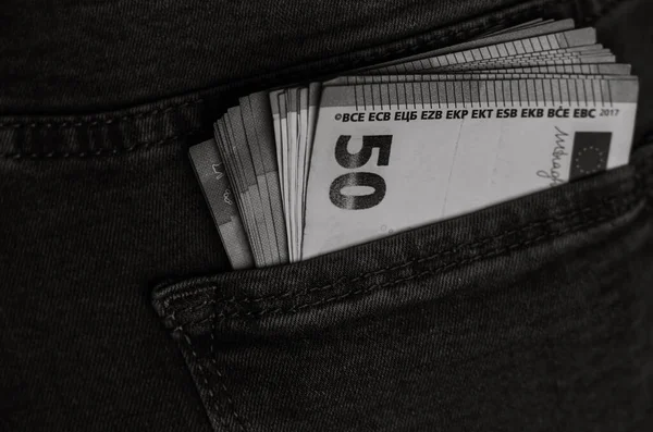 Banknotes close up, money in a jeans pocket. EURO stick out of the jeans pocket, finance and currency concept. Concept of saving or spending money